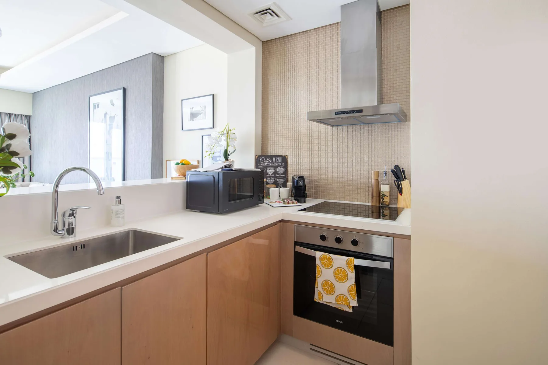 Una cocina moderna con fregadero, placa de cocción y horno integrado.
