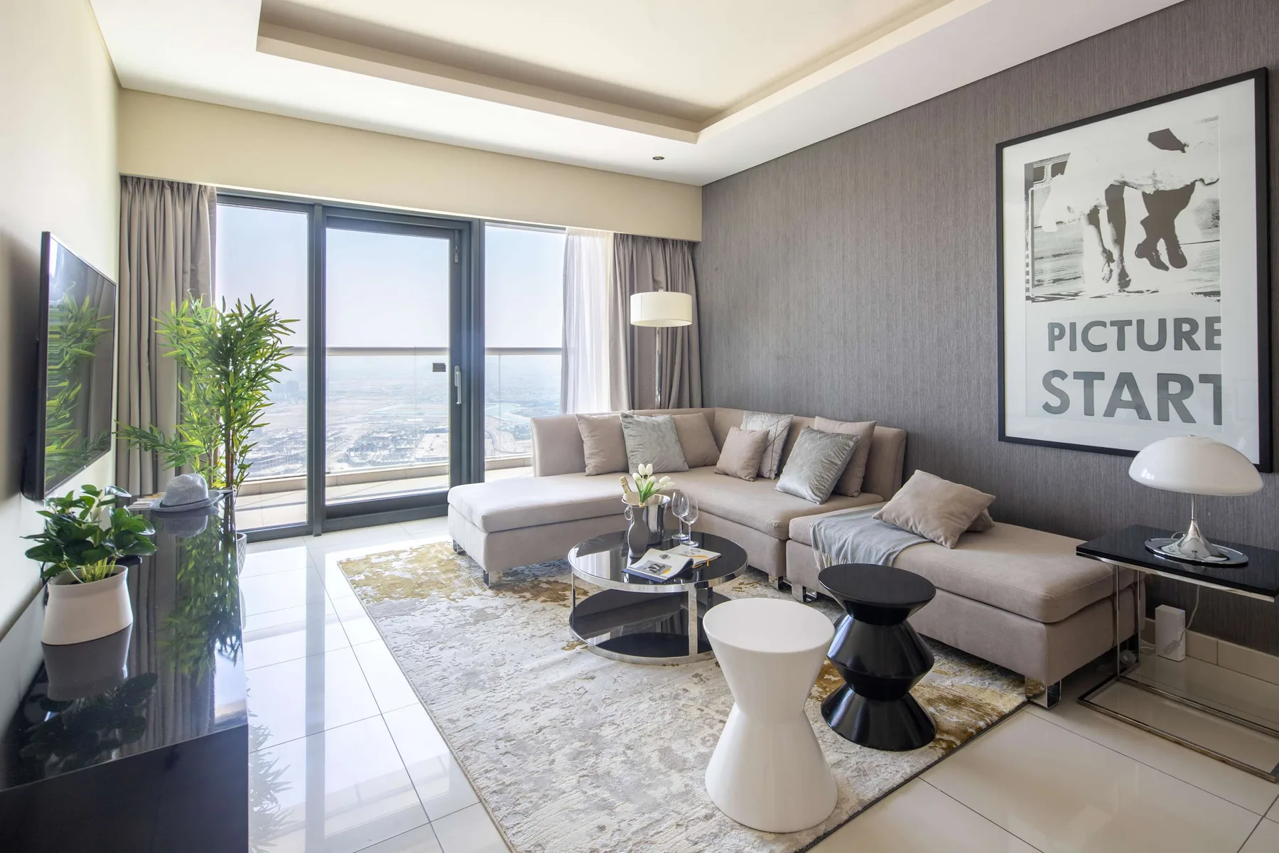 Sala de estar con una zona de asientos junto a grandes ventanas.