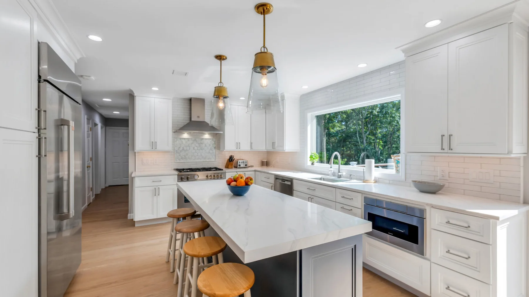 A bright kitchen with a large island and stainless steel appliances.