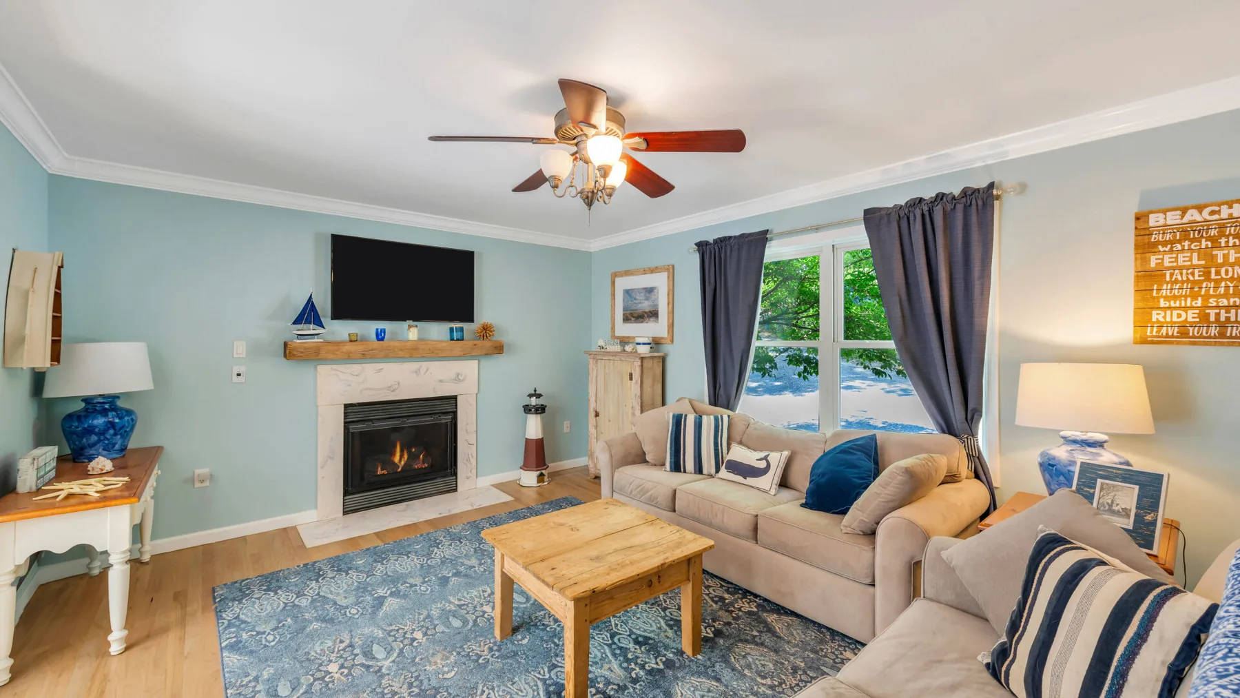 A living room with seating around a wooden coffee table and a fireplace.
