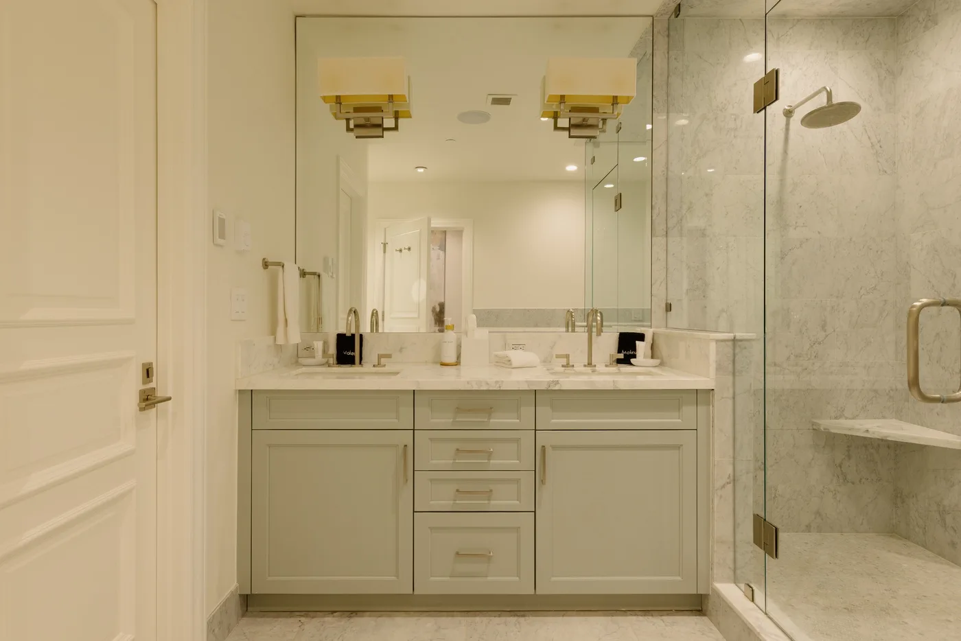 A bright bathroom with a wide vanity and a glass-enclosed shower.