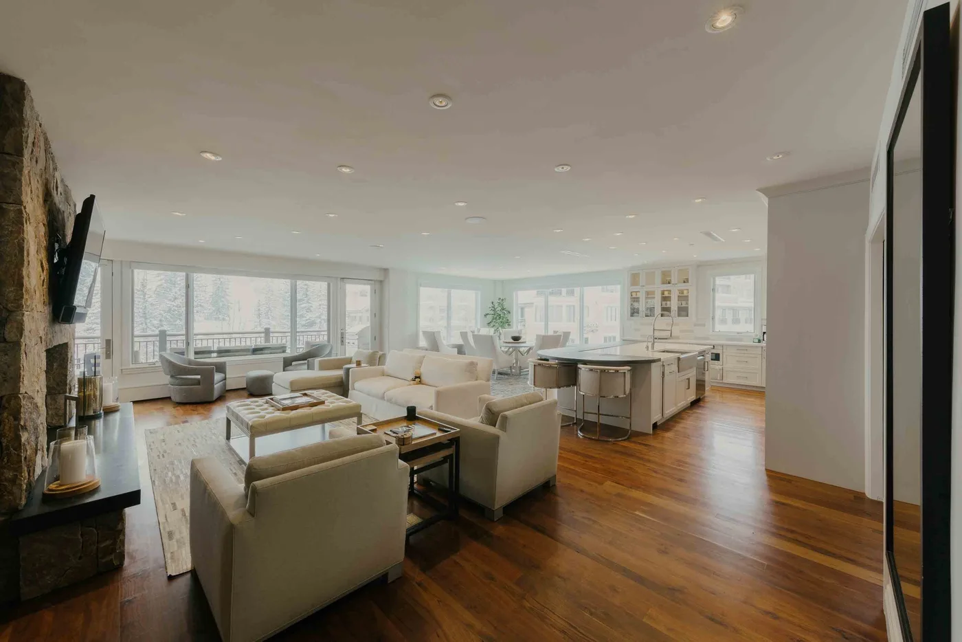 A bright open-plan living and dining area with large windows and wood flooring.