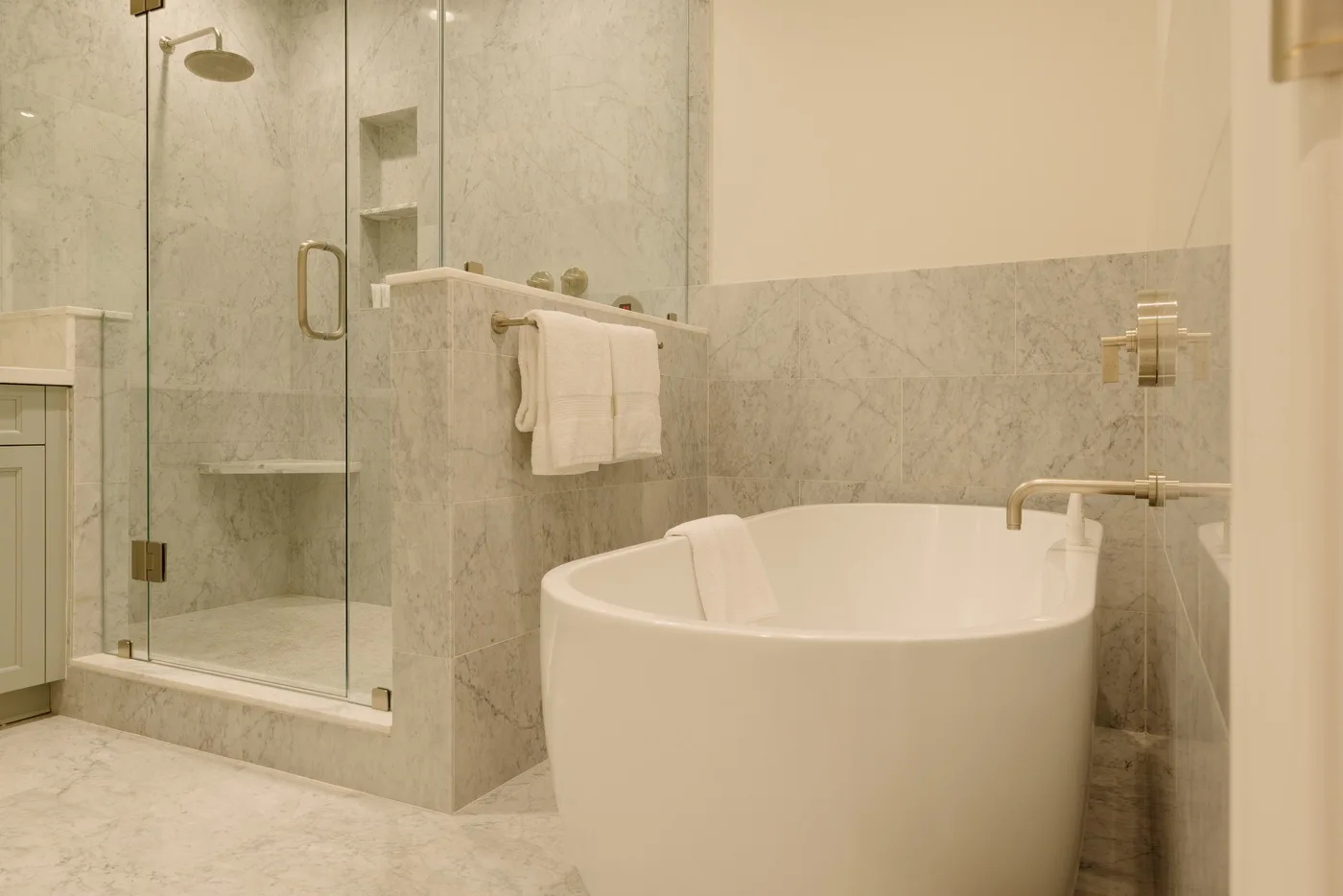 A bathroom with a freestanding bathtub and glass shower area.