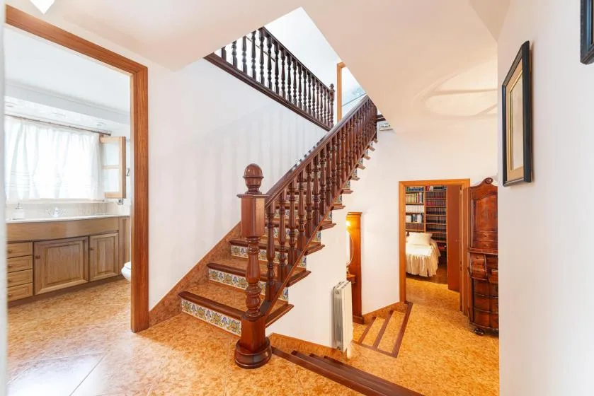 An interior hallway with a wooden staircase leading to an upper level.