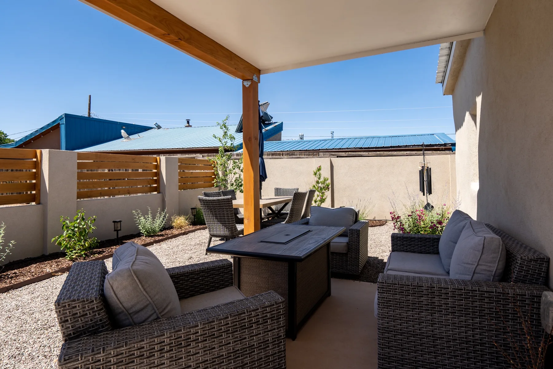 A shaded outdoor seating area with wicker furniture and a low table.