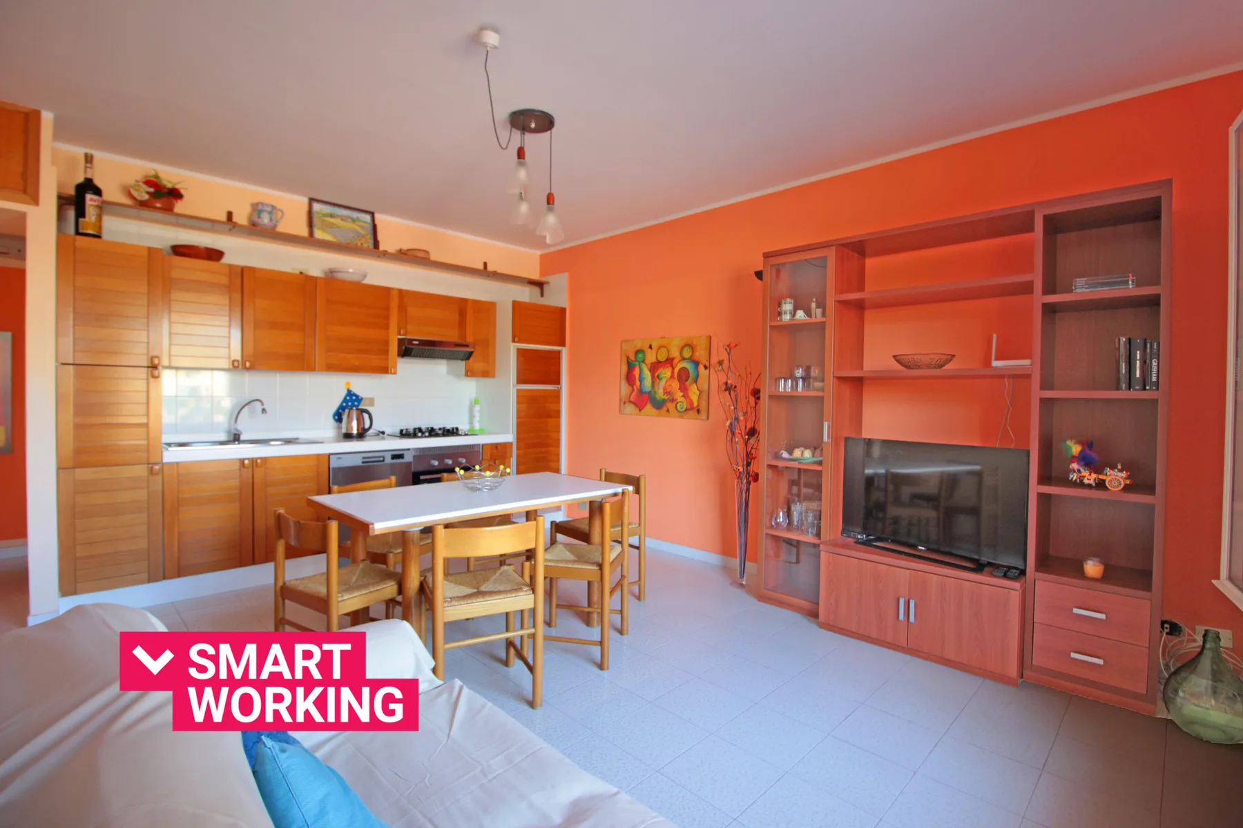 An open-plan kitchen and dining area with wooden cabinets and a table.