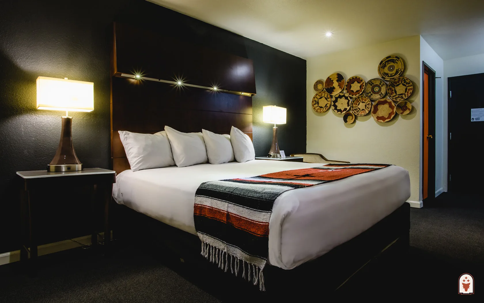 Habitación con una cama king, televisor, faroles y cortinas azules