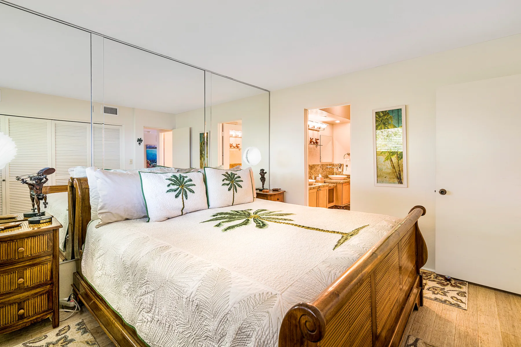 Un dormitorio con una cama grande y puertas de armario con espejos.