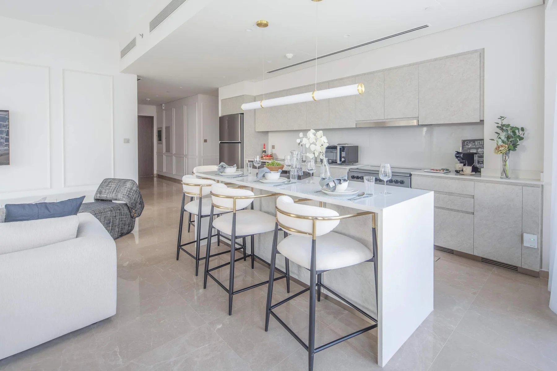 Una luminosa cocina abierta al comedor, con una isla grande y asientos.