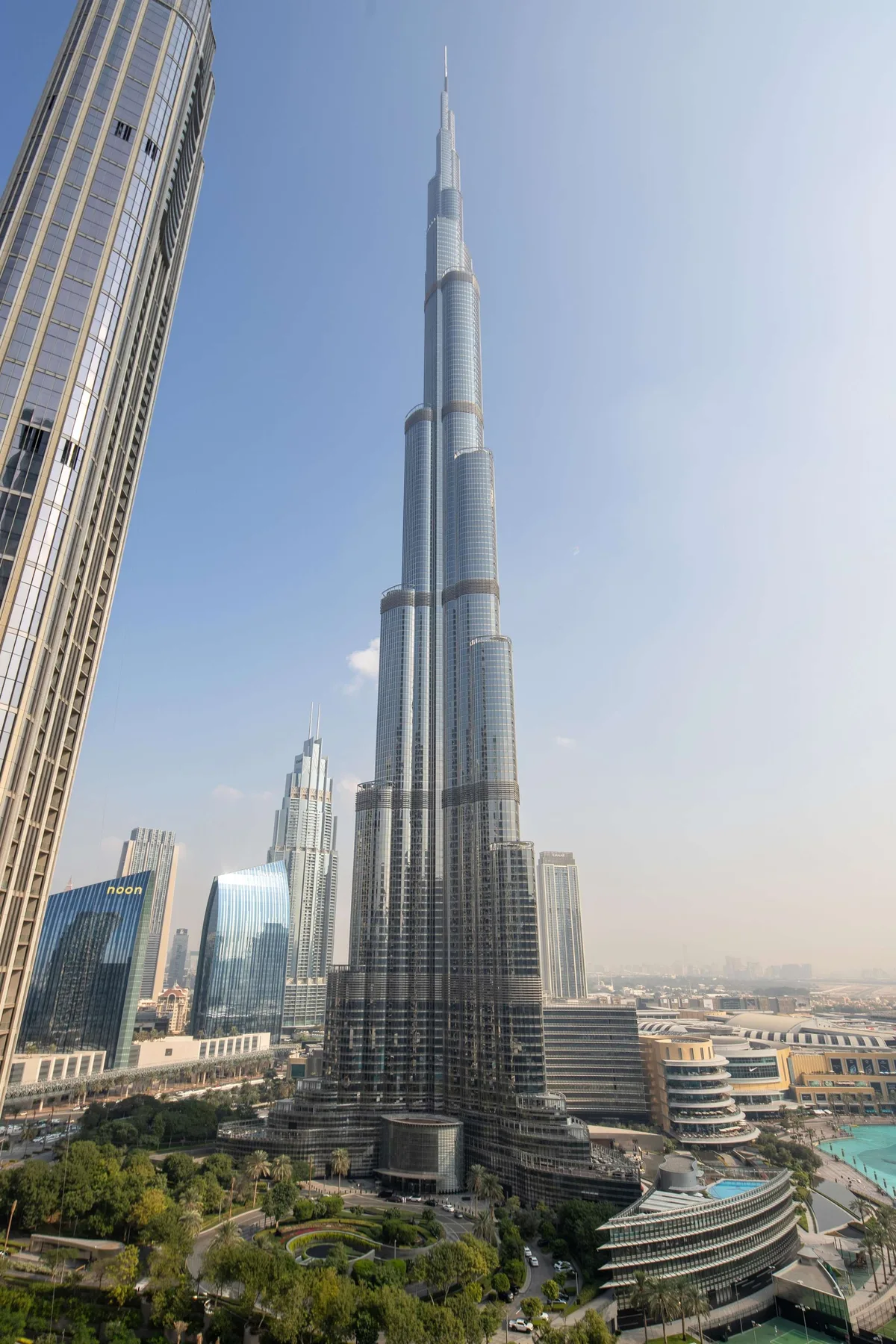El Burj Khalifa se eleva sobre rascacielos cercanos y zonas ajardinadas.