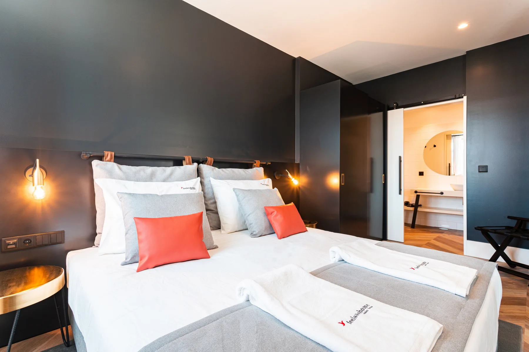 Dormitorio con una cama bien hecha y paredes oscuras.