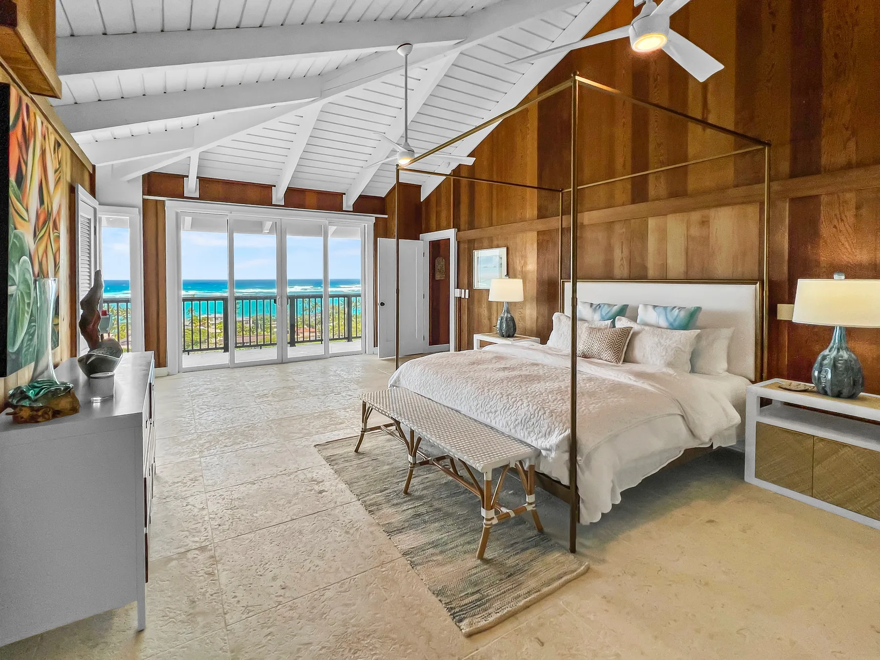 A bedroom with a large bed and glass doors opening onto a balcony.