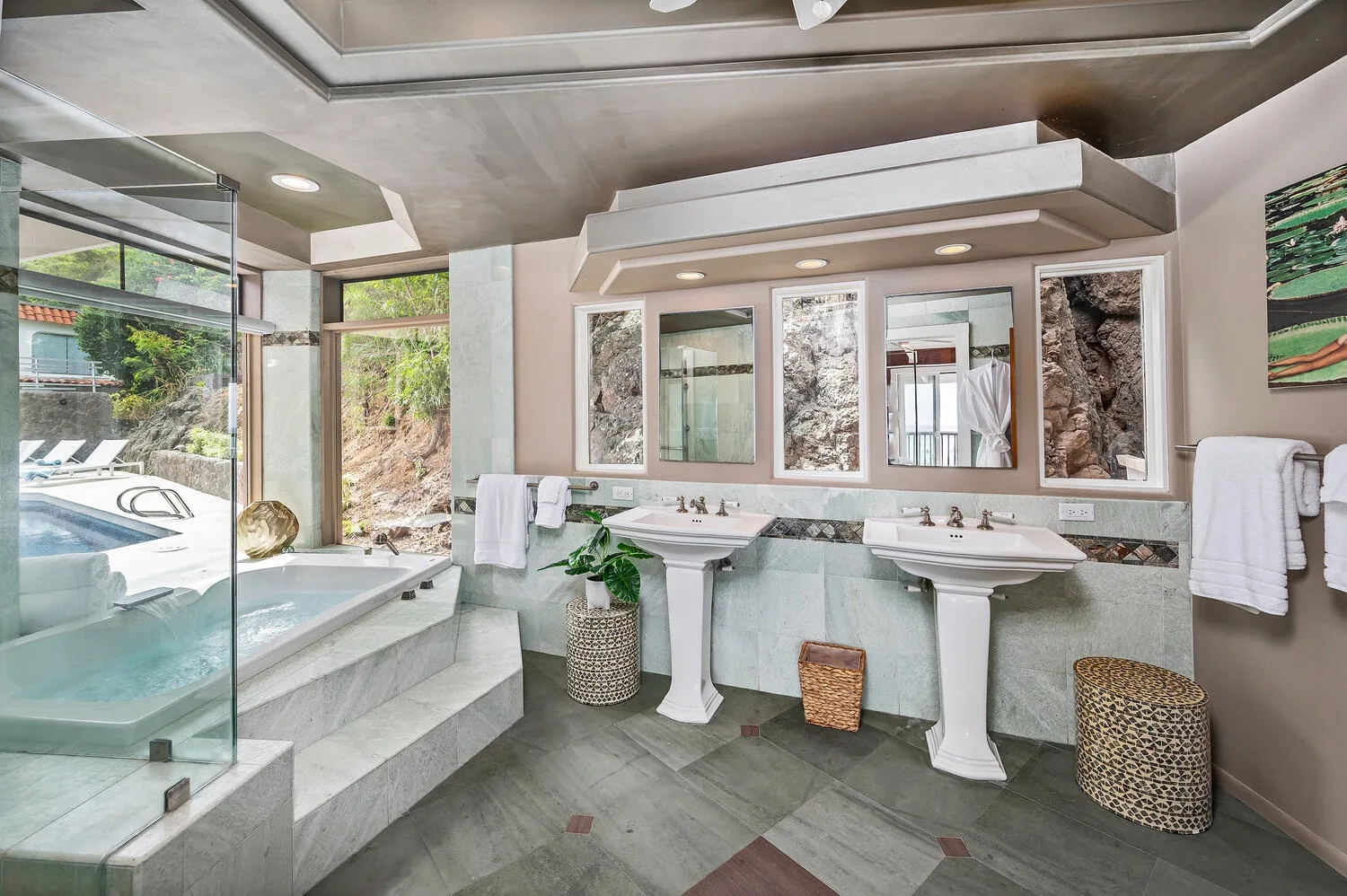 A bright bathroom with two sinks and a glass-enclosed bathtub.