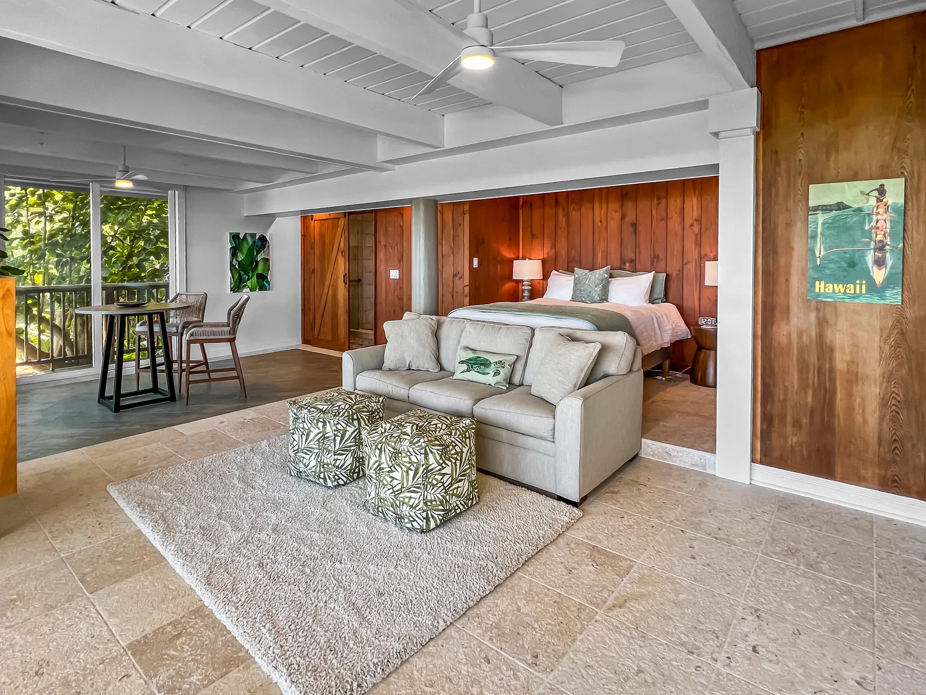 A bedroom and sitting area with a bed, seating, and a small dining table.
