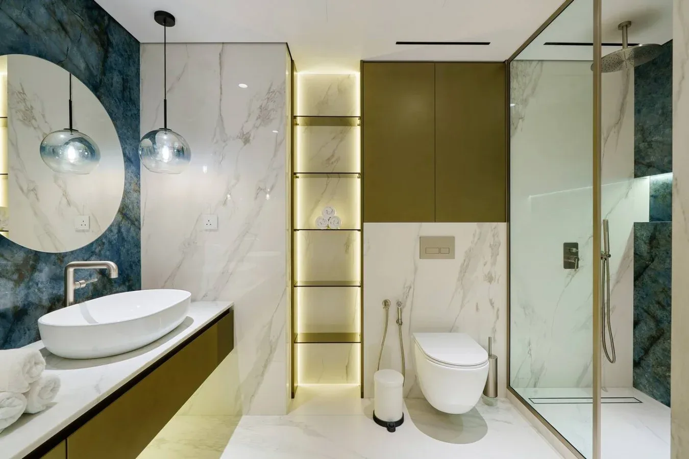 Un baño moderno con lavabo sobre encimera, inodoro suspendido y ducha de cristal.