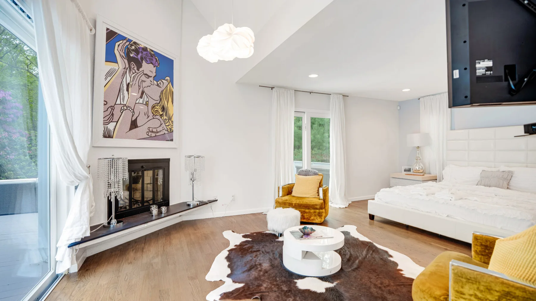A bright living room with a white seating area and a round coffee table.