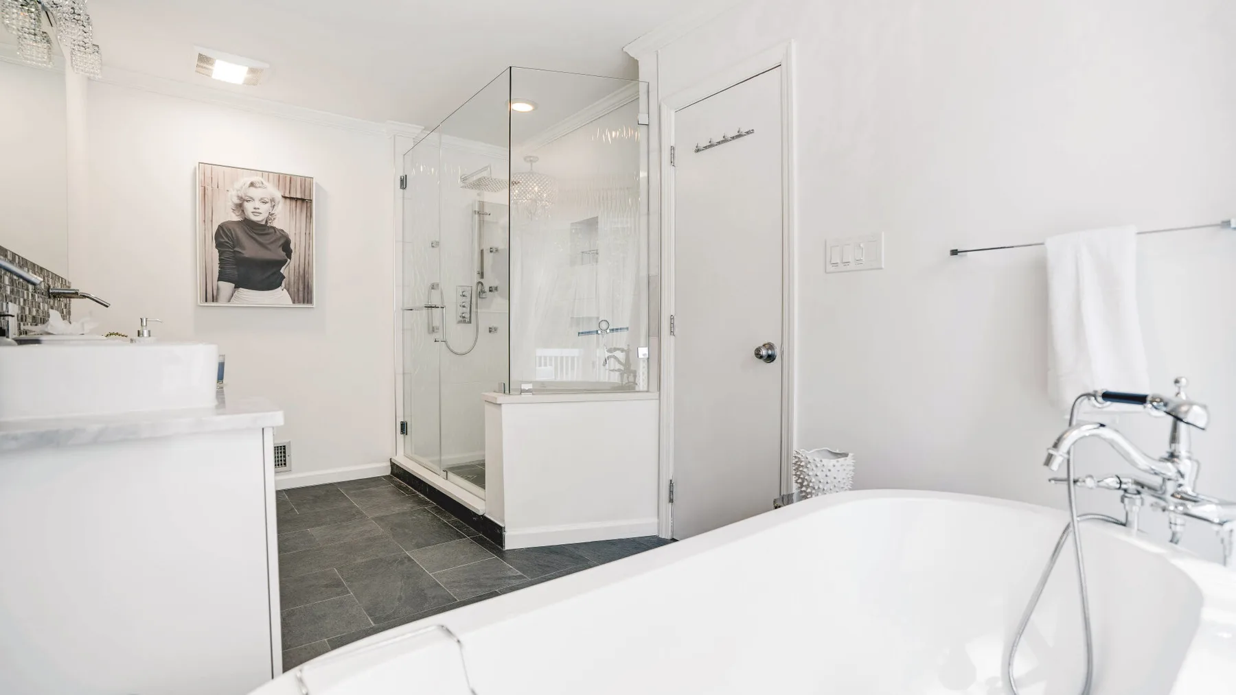 A bright bathroom with a glass shower and a freestanding bathtub.