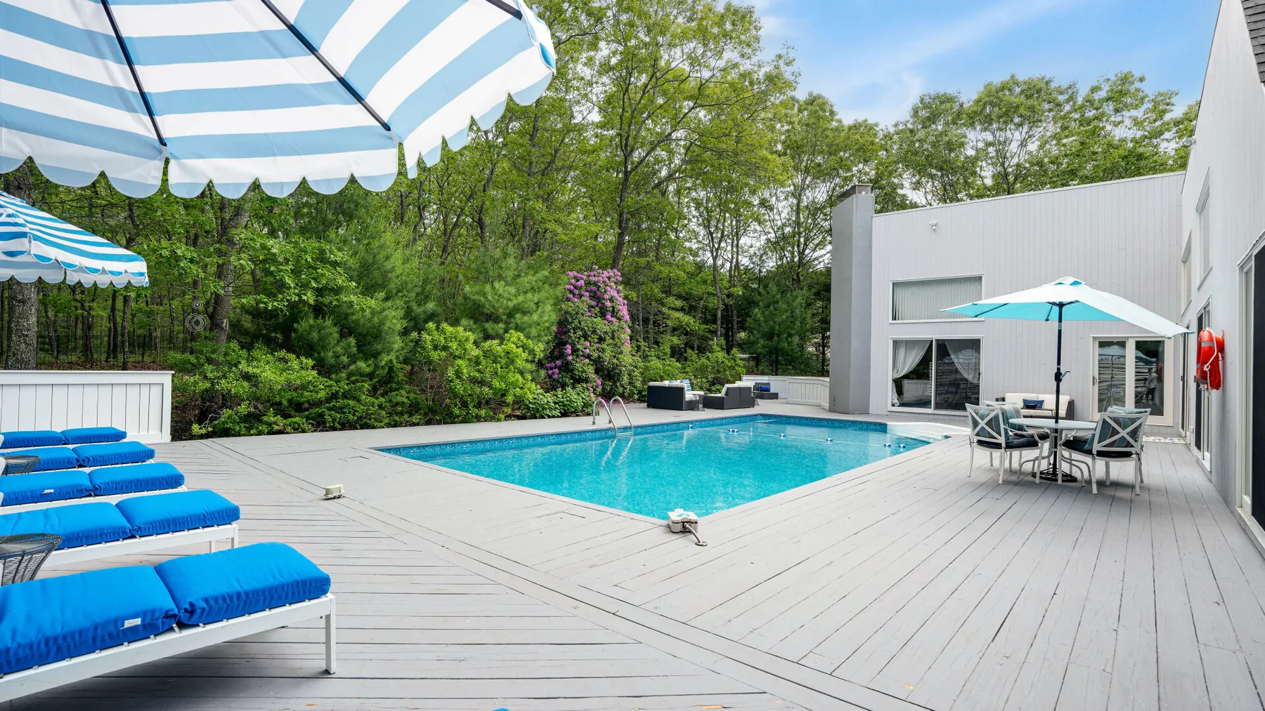 An outdoor swimming pool is surrounded by a spacious deck and seating.