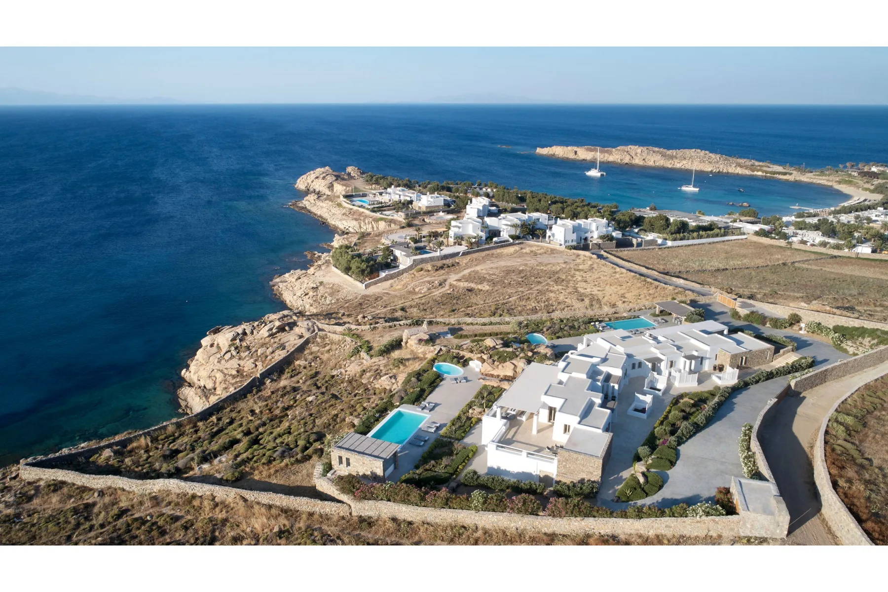 Aerial view of coastal buildings beside the sea and a small bay.