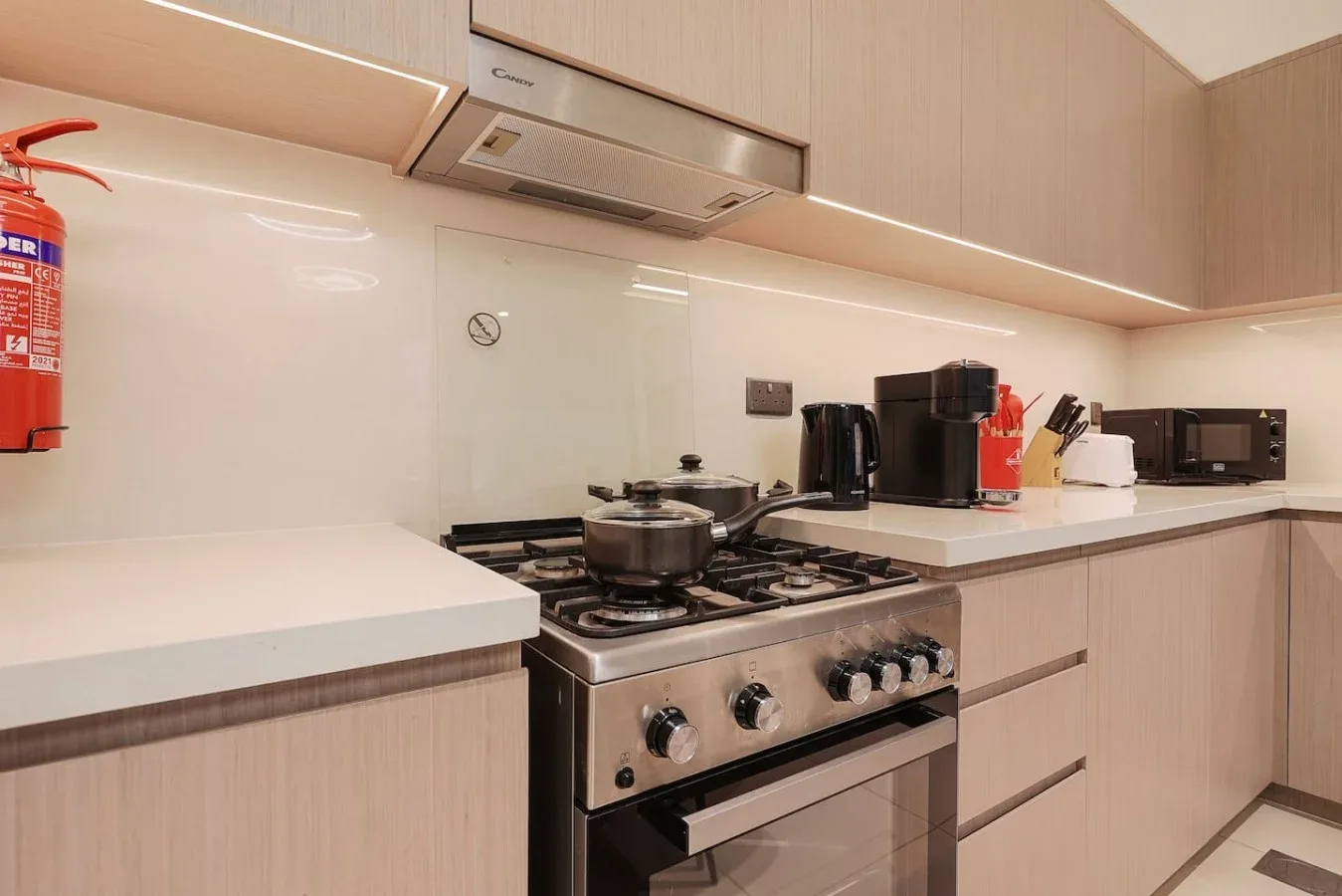 Una cocina moderna con estufa de gas, horno y electrodomésticos sobre la encimera.