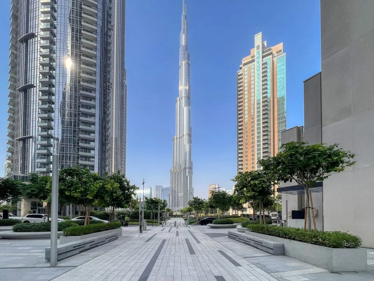 Una plaza peatonal pavimentada con el Burj Khalifa entre las torres cercanas.