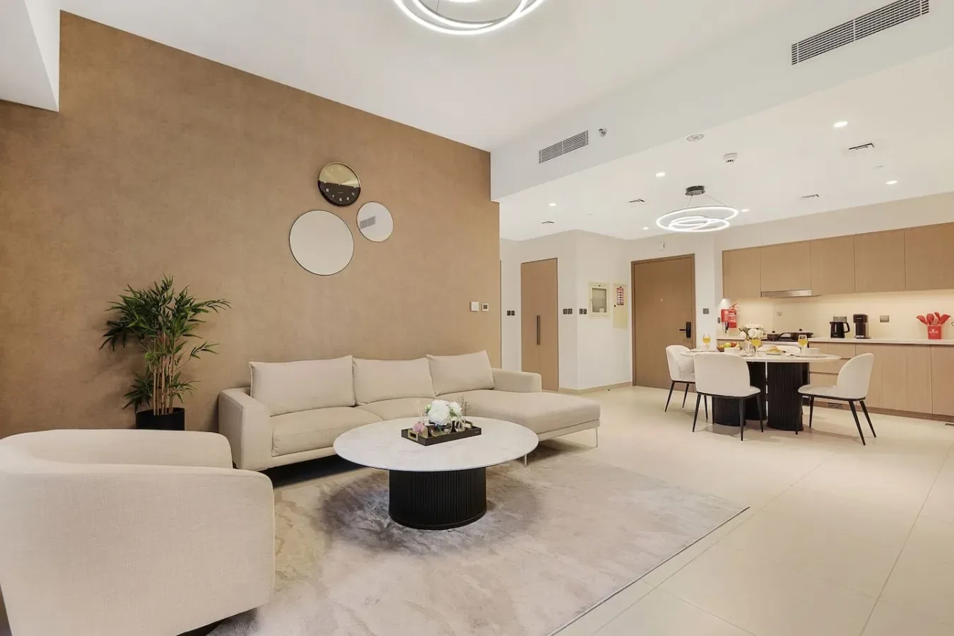 Una sala de estar moderna con una zona de asientos y una barra de cocina abierta.