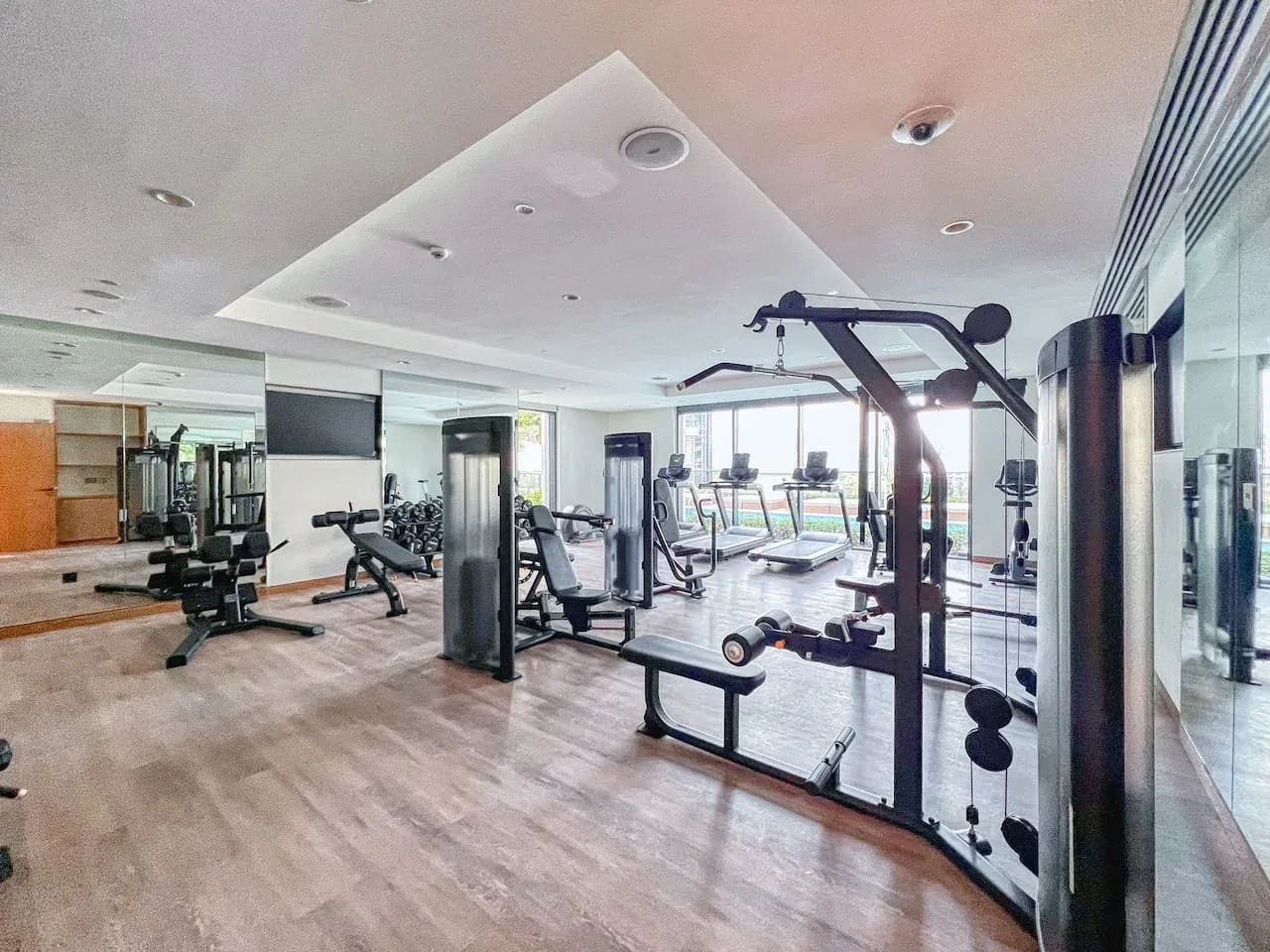 Un gimnasio amplio con máquinas de ejercicio y equipo de entrenamiento con pesas.
