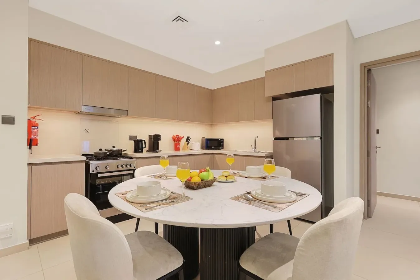 Una mesa de comedor con cubiertos está en una cocina moderna.