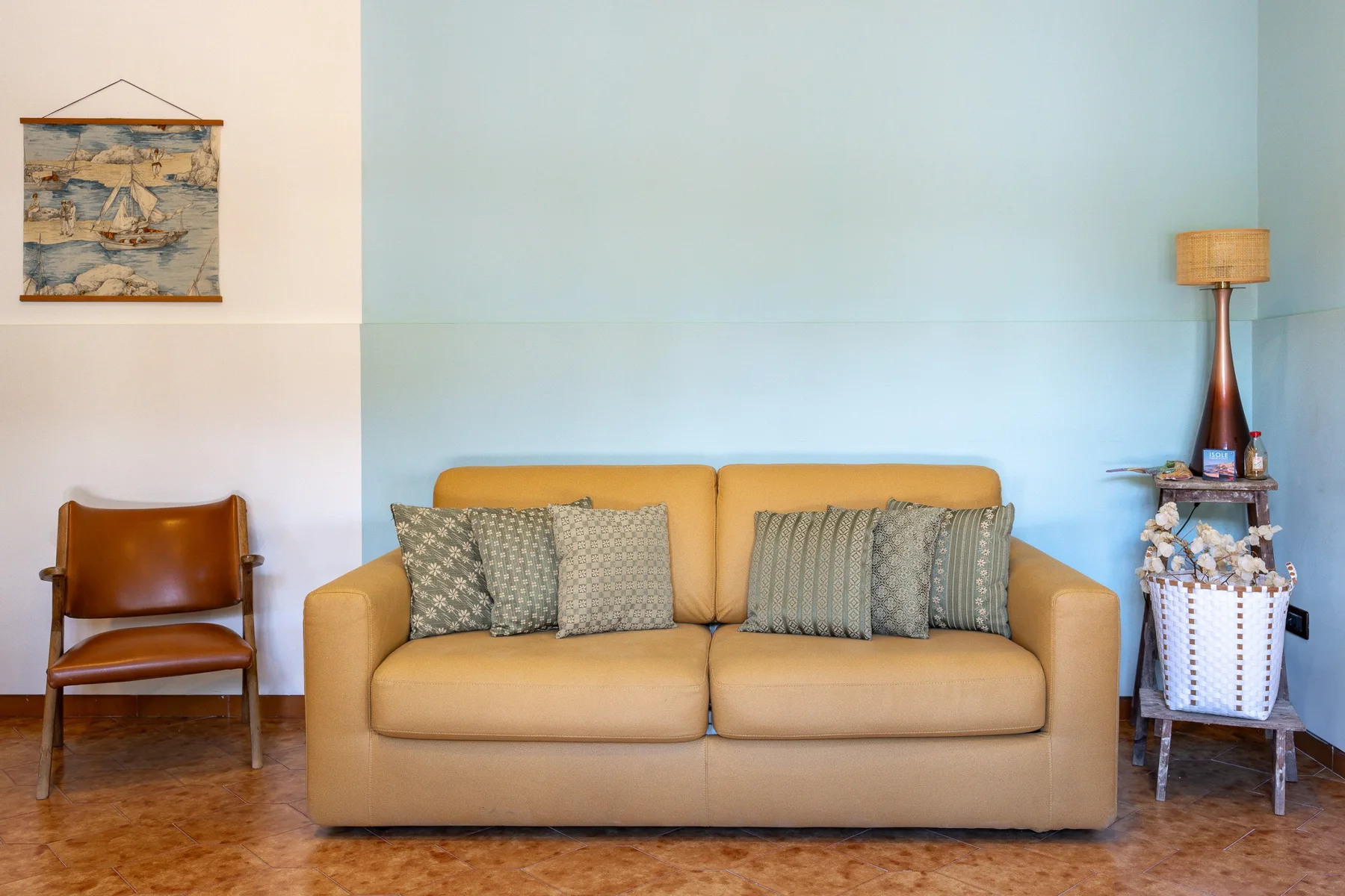 Una sala de estar con un sofá beige y una silla de madera.