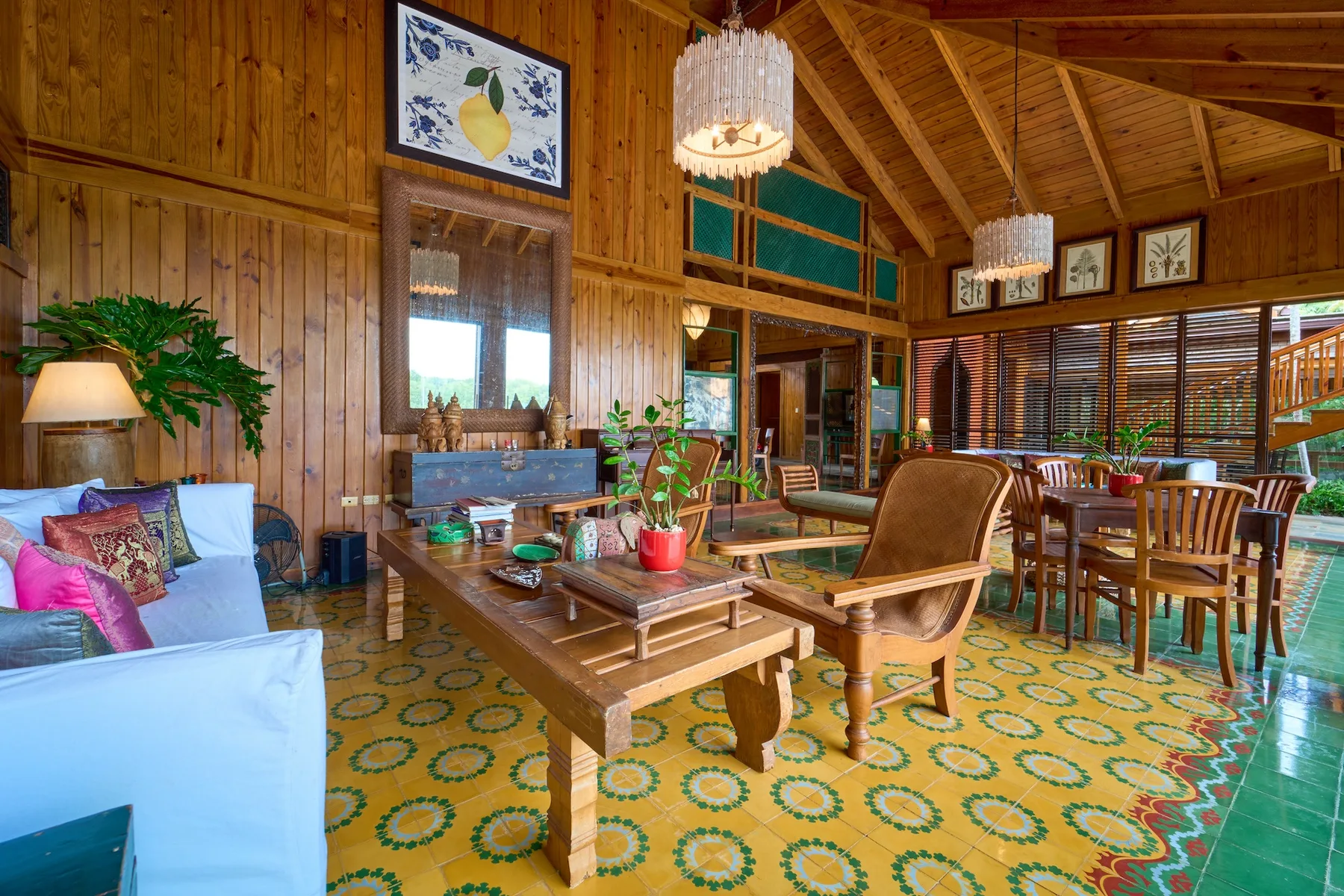 Una sala-comedor revestida de madera con asientos, una mesa y una alfombra estampada.