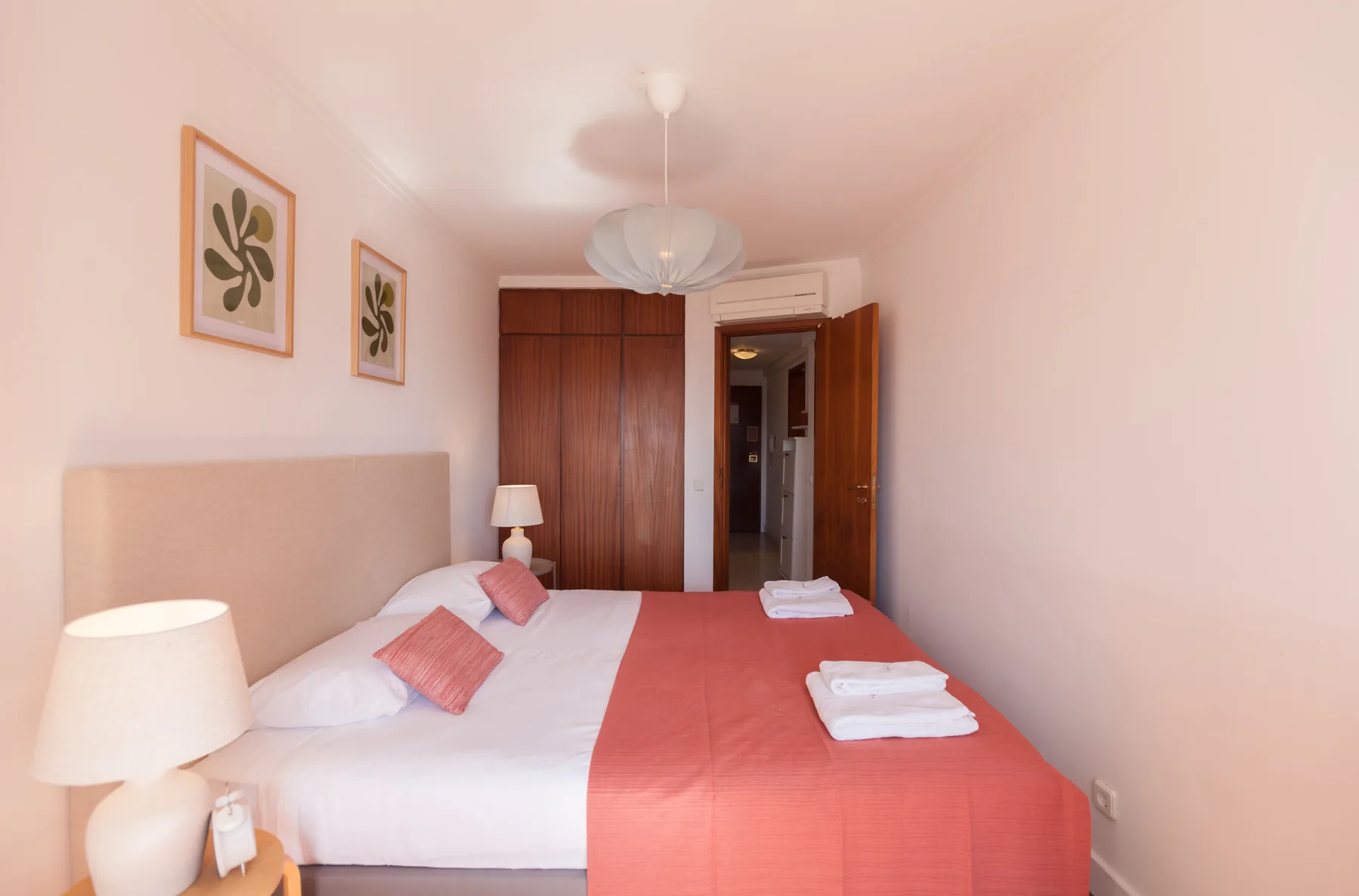 Un dormitorio con una cama bien tendida y toallas dobladas.