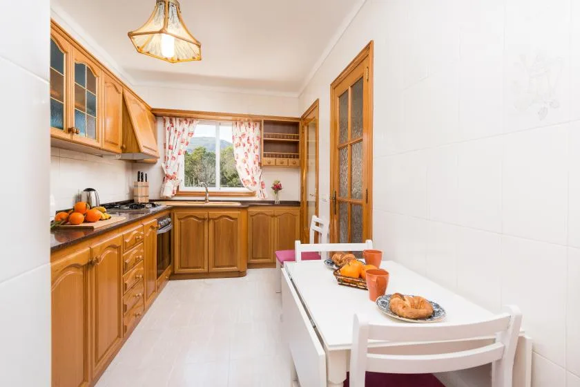 A bright kitchen with wooden cabinets and a dining table.