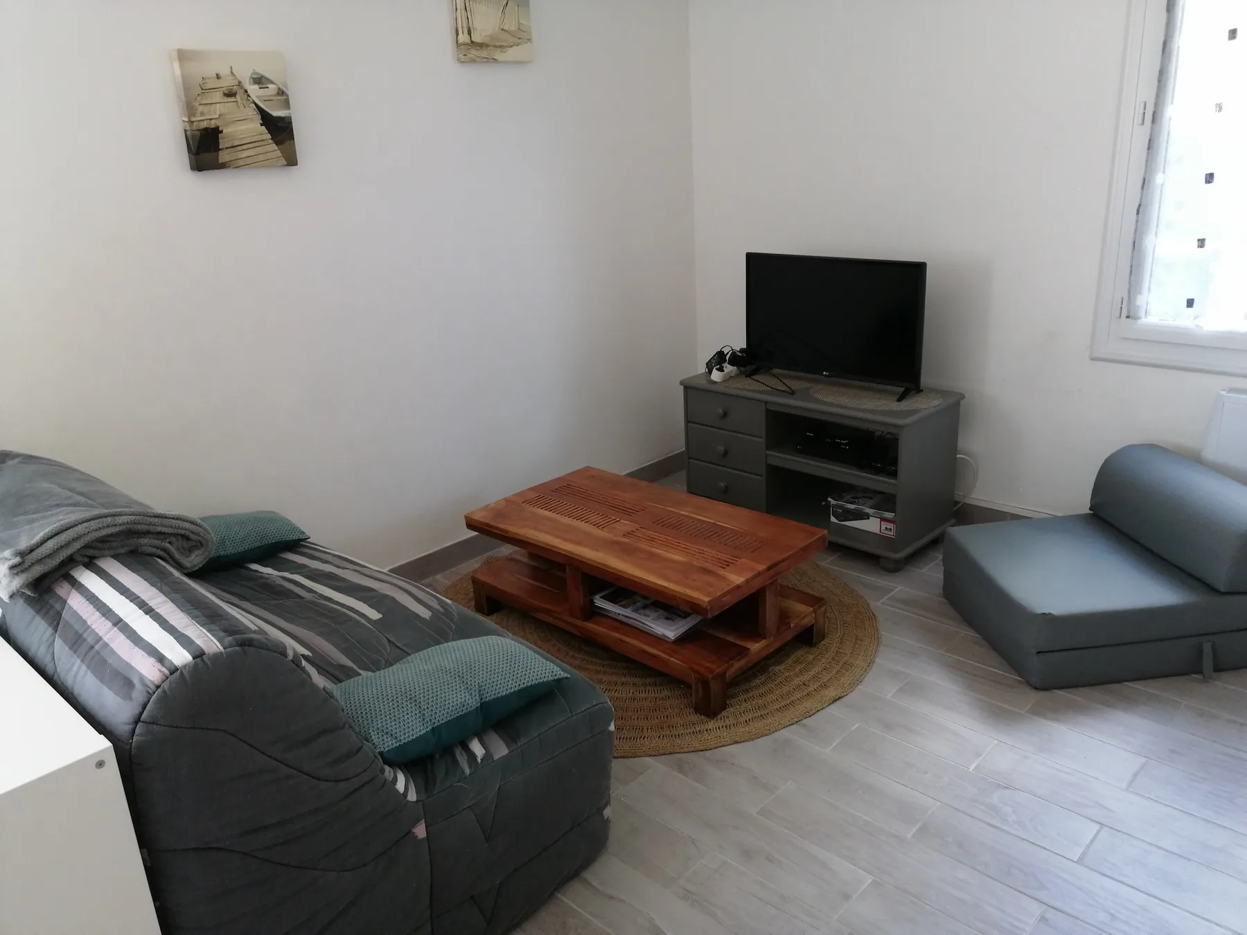A living room with seating around a wooden coffee table and television.