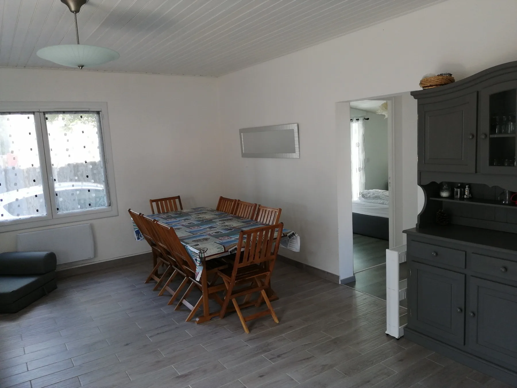 Dining area with a wooden table and chairs beside a window.
