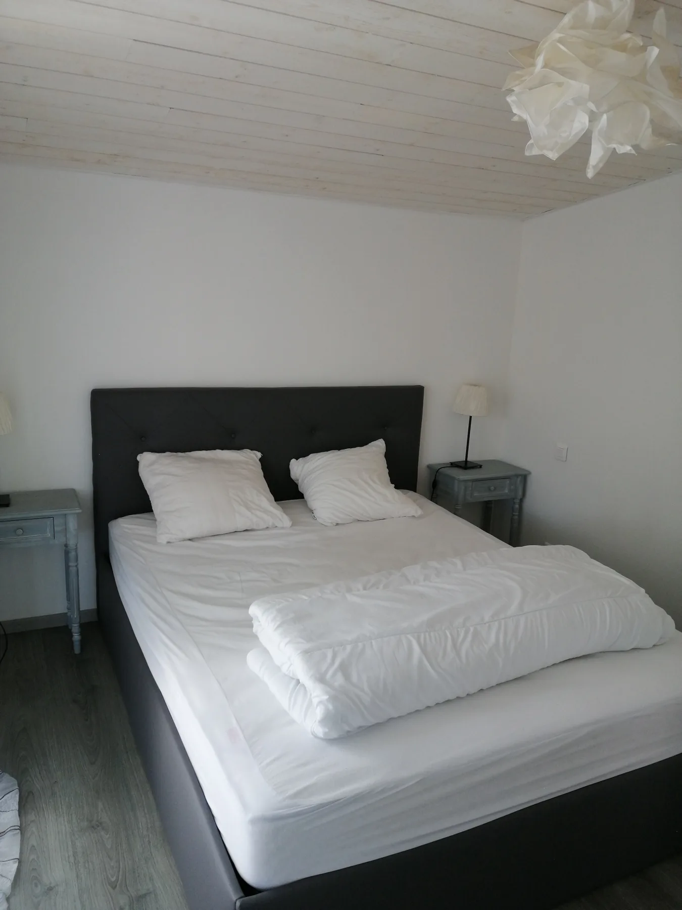 A bedroom with a neatly made bed and matching bedside tables.