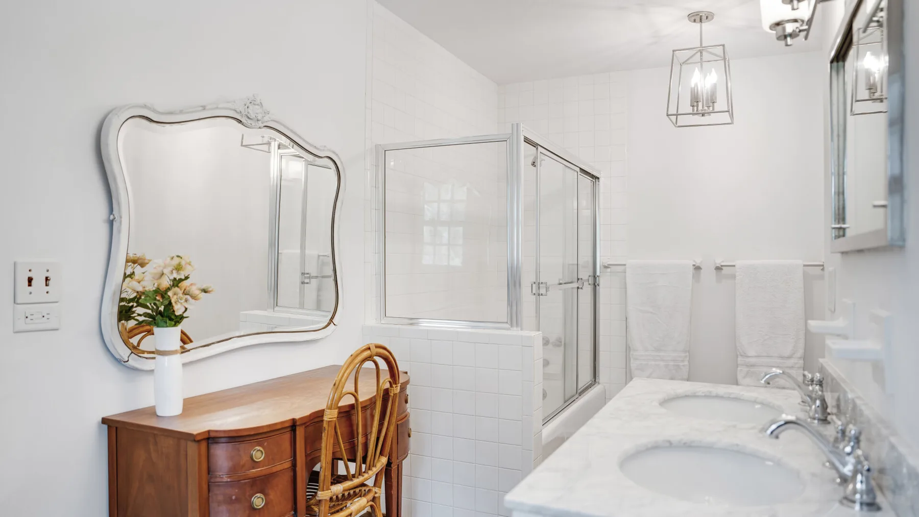 Un baño luminoso con bañera, lavabo y tocador de madera.