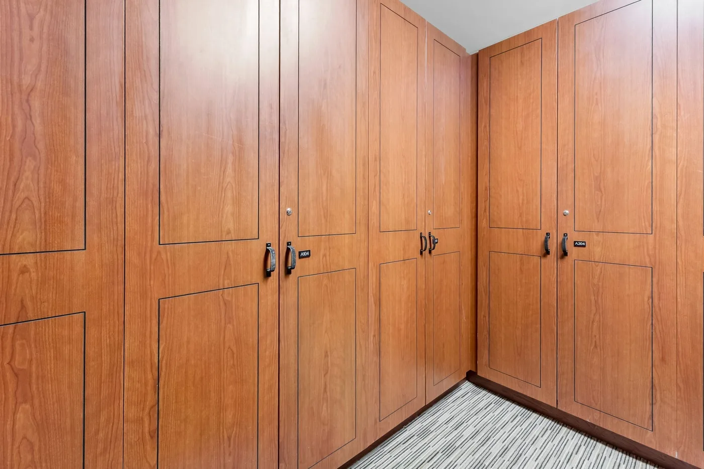 A corner lined with wooden cabinets above a patterned floor.