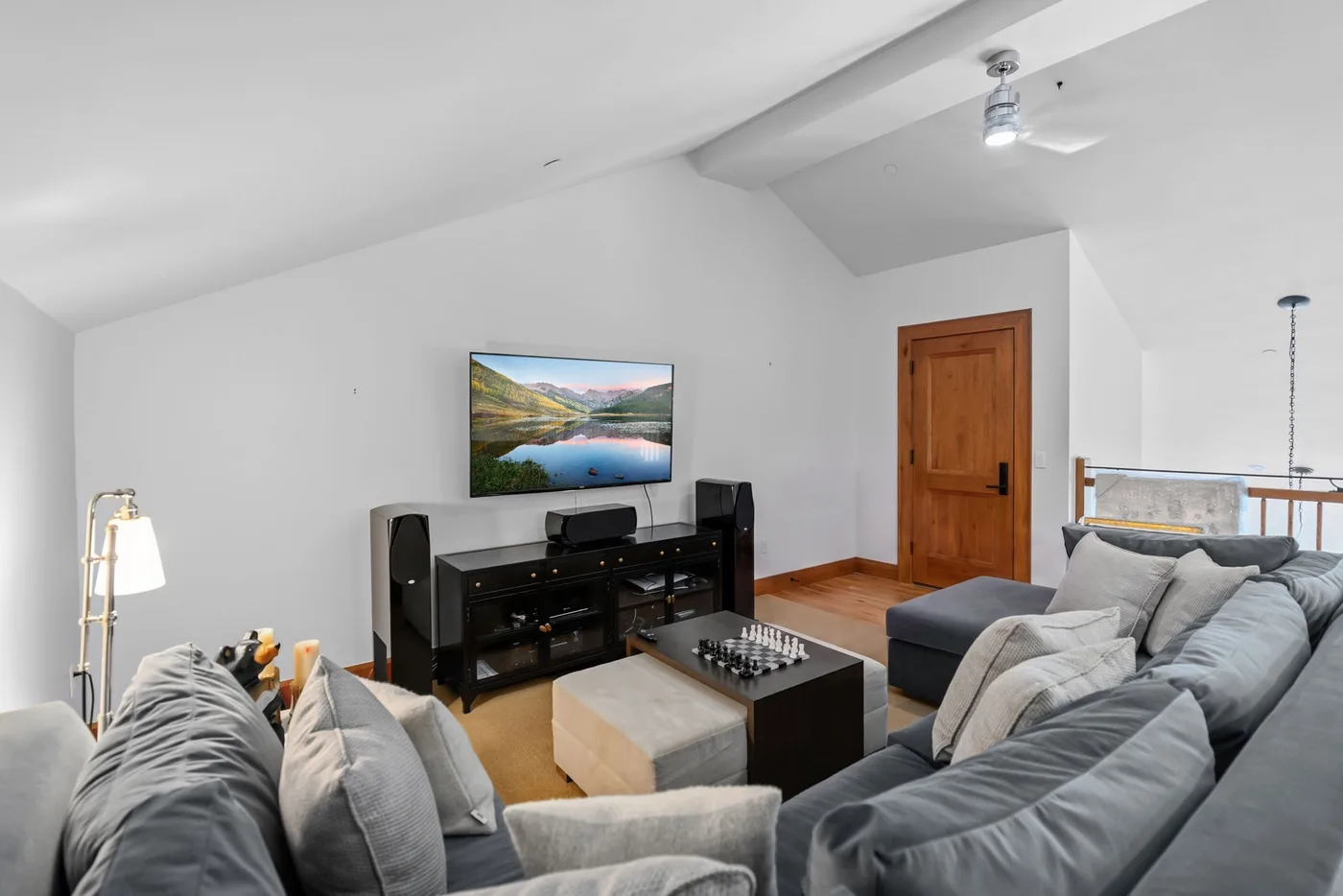 A living room with gray seating, a television, and a coffee table.