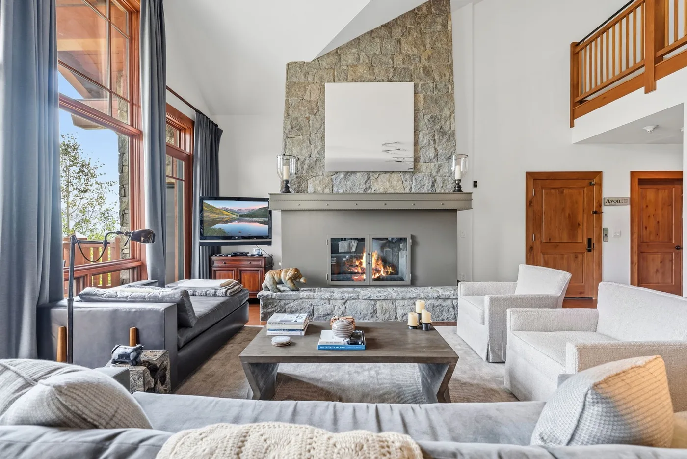 A spacious living room features seating around a coffee table and a fireplace.