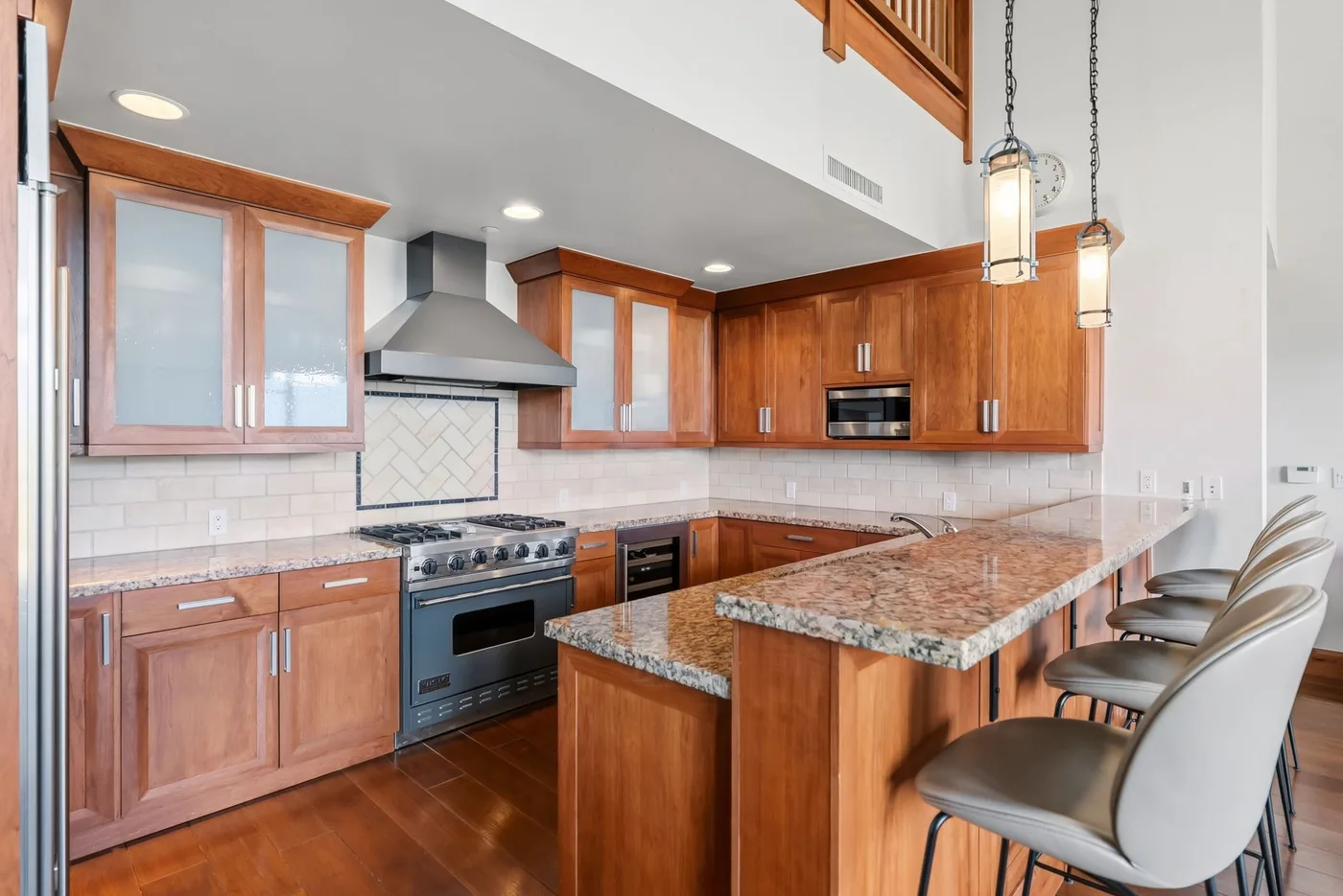 A kitchen with wooden cabinets, a cooking range, and a central island with seating.