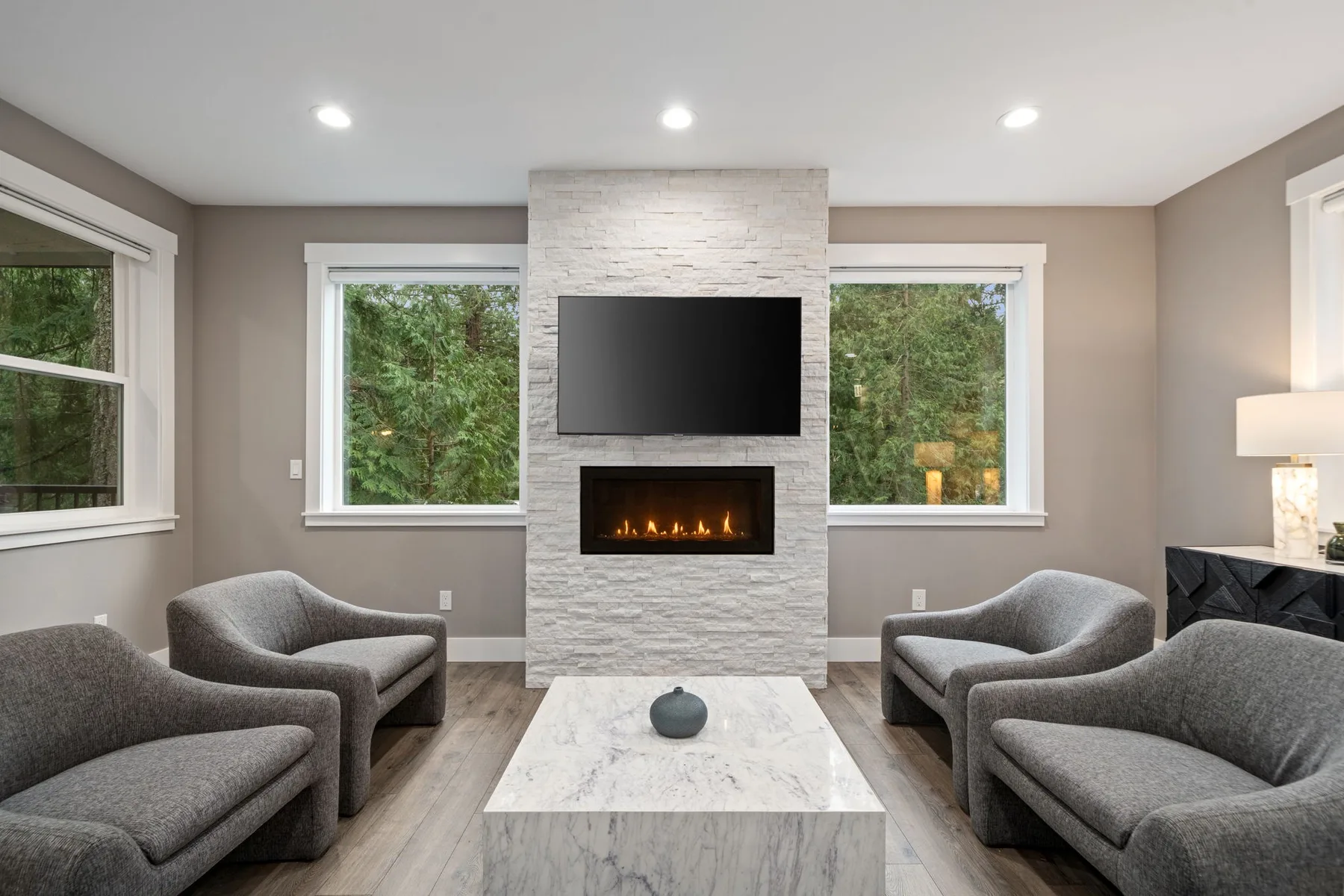 Una sala de estar con asientos dispuestos alrededor de una chimenea y un televisor.