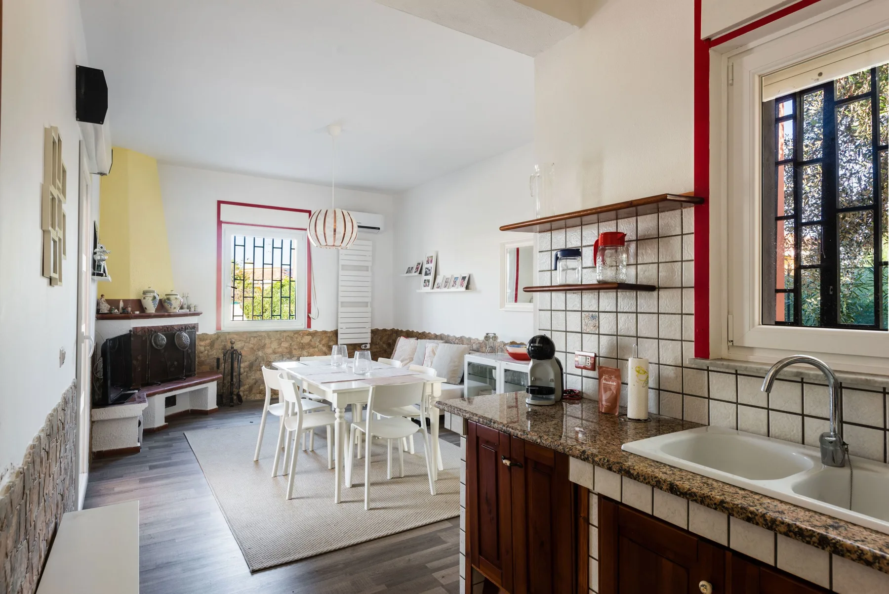Una cocina y comedor luminosos con una mesa junto a la encimera.