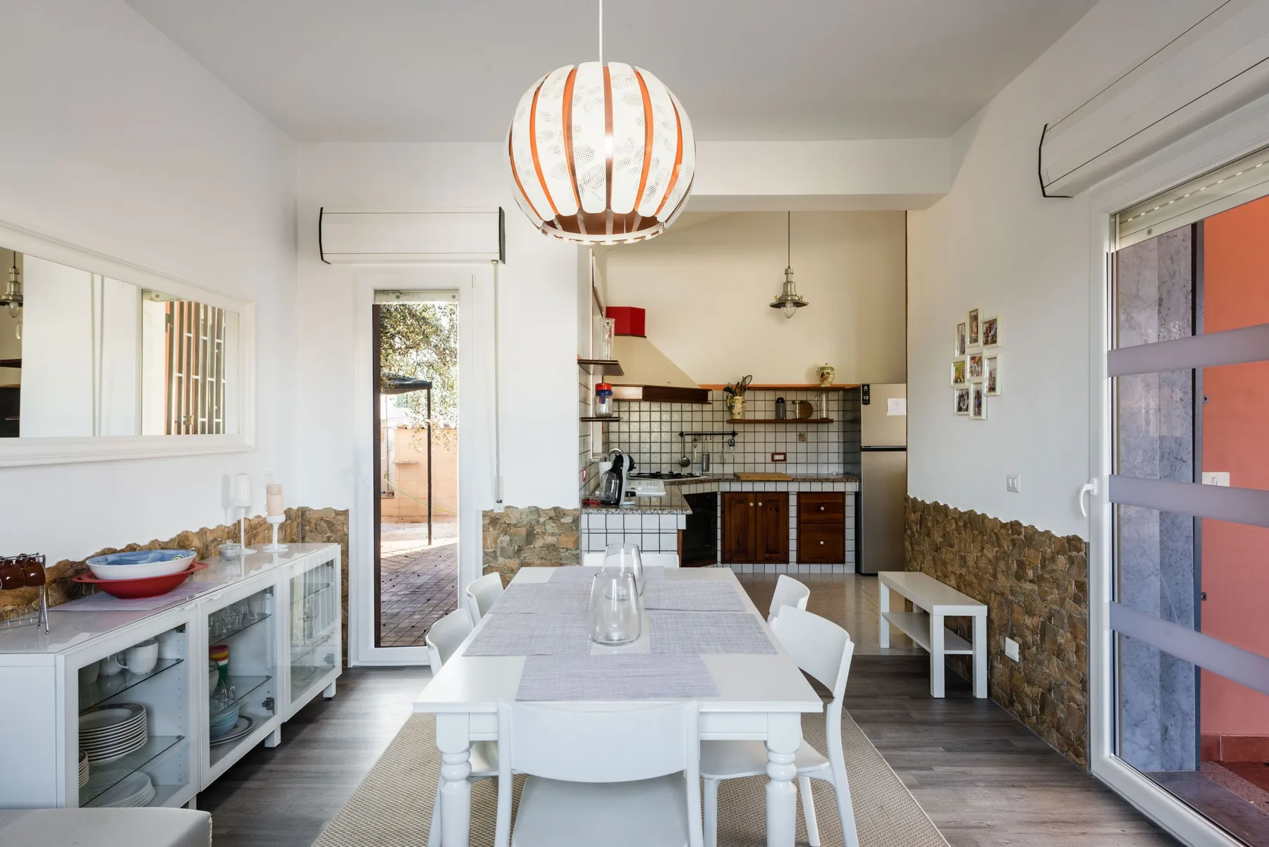 Un comedor luminoso con una mesa blanca está frente a una cocina abierta.