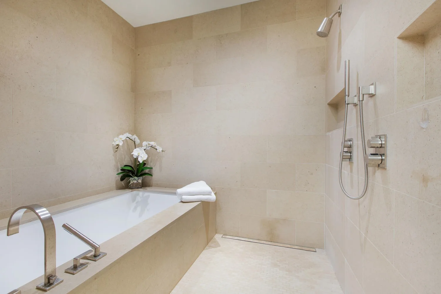 Un baño con bañera y accesorios de ducha montados en la pared.