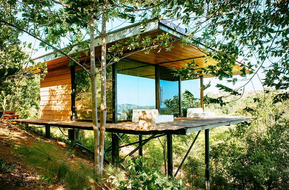 Wooden bungalow on stilts among the trees