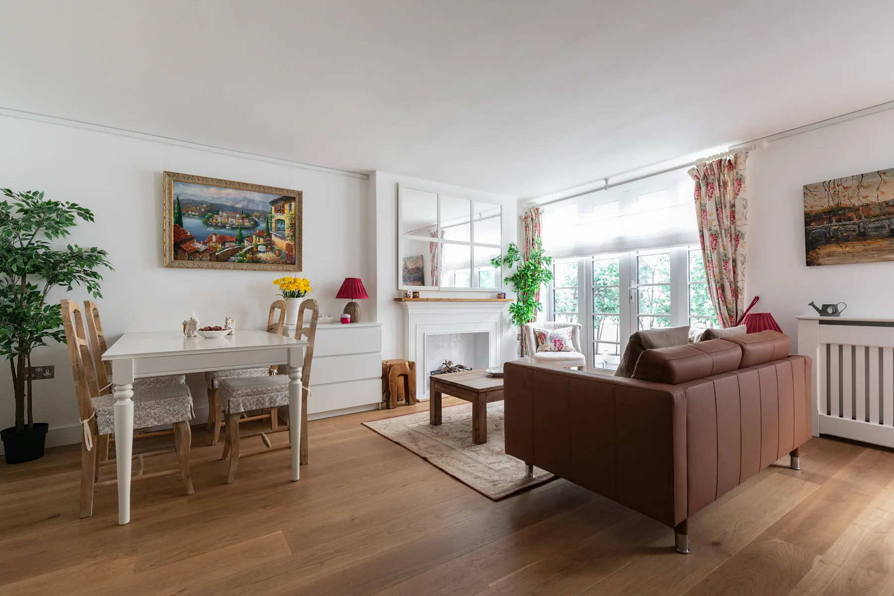 A bright living room with a dining table and brown seating.