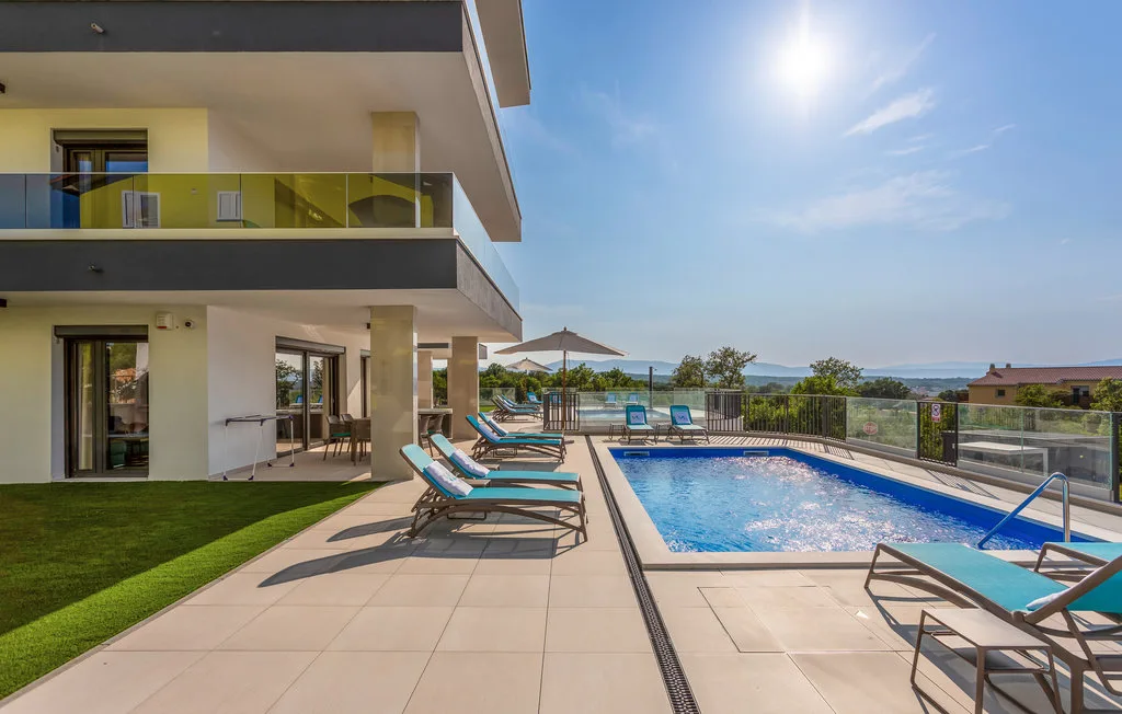 Outdoor pool and tiled patio beside a modern building.