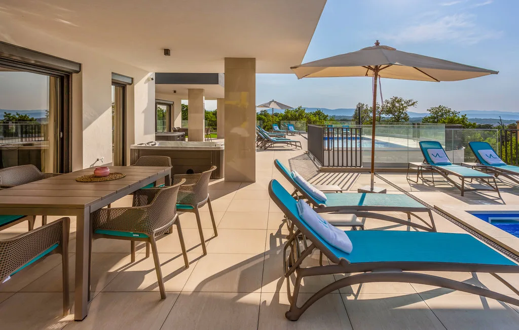 An outdoor poolside patio has turquoise loungers, a shaded table, and dining seating.
