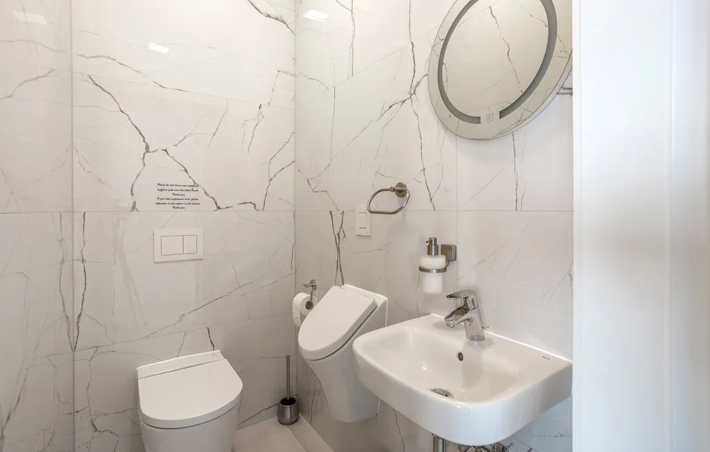 A bright bathroom with a wall-mounted sink and toilet.