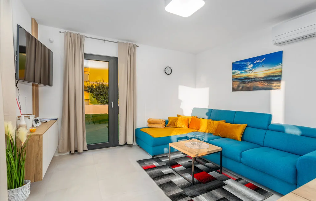 A living room with blue seating, colorful cushions, and a coffee table.